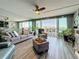 Open living room with ample seating, ceiling fan, sliding glass doors to balcony, and beautiful water views at 500 Treasure Island Cswy # 207, Treasure Island, FL 33706