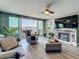 Spacious living room boasts water views, a fireplace, and comfortable seating with a ceiling fan overhead at 500 Treasure Island Cswy # 207, Treasure Island, FL 33706