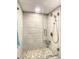 Shower with glass door, tiled walls, handheld showerhead, and tiled flooring at 500 Treasure Island Cswy # 207, Treasure Island, FL 33706