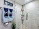 Shower stall with stone flooring, neutral tile walls, and storage at 500 Treasure Island Cswy # 207, Treasure Island, FL 33706