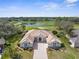 Expansive home with a tile roof overlooking a lush golf course and serene pond on a sunny day at 5021 Championship Cup Ln, Spring Hill, FL 34609