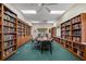 Bright library featuring walls of bookshelves, a large table with chairs, and ceiling fans at 5021 Championship Cup Ln, Spring Hill, FL 34609