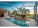 The screened pool features palm trees and a view of the golf course at sunset at 5021 Championship Cup Ln, Spring Hill, FL 34609