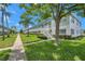 Two-story residential apartment building with grass, landscaped bushes and walkway at 5246 81St N St # 24, St Petersburg, FL 33709