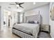 Elegant bedroom featuring a tufted headboard bed, modern decor, and hardwood floors at 6926 Rocky Canyon Way, Tampa, FL 33625