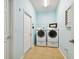 Bright laundry room features a washer, dryer, tile floors, and a window providing natural lighting and ventilation at 6926 Rocky Canyon Way, Tampa, FL 33625