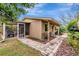 Back exterior view with screened-in porch, paver walkway, garden beds, and outdoor seating area at 702 59Th S St, Gulfport, FL 33707