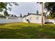 Spacious backyard with green grass, white fence, and mature trees at 715 Virginia Ave, Tarpon Springs, FL 34689