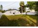 Green backyard with mature trees and white fenced perimeter at 715 Virginia Ave, Tarpon Springs, FL 34689