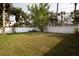 Expansive green backyard, surrounded by mature trees and a white privacy fence at 715 Virginia Ave, Tarpon Springs, FL 34689