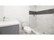 Bright bathroom with modern tiling in the shower, gray vanity, and tiled floors at 715 Virginia Ave, Tarpon Springs, FL 34689