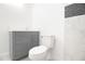 Bathroom featuring a gray vanity, white toilet, and marble wall tiles with black accent at 715 Virginia Ave, Tarpon Springs, FL 34689