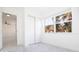 Bright bedroom featuring light gray floors, closet, and view of trees outside at 715 Virginia Ave, Tarpon Springs, FL 34689