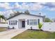 Welcoming home featuring a manicured lawn, white picket fence, and freshly planted greenery for enhanced curb appeal at 715 Virginia Ave, Tarpon Springs, FL 34689