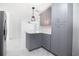 Bright, open-concept kitchen and living area featuring gray cabinets, quartz countertops, and modern pendant lighting at 715 Virginia Ave, Tarpon Springs, FL 34689
