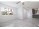 Bright living room featuring a large window, sleek ceiling fan, and an open layout flowing into the kitchen at 715 Virginia Ave, Tarpon Springs, FL 34689