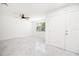 Bright living room with new white walls, modern ceiling fan, and stylish gray marble-look tile flooring at 715 Virginia Ave, Tarpon Springs, FL 34689