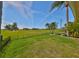 Back yard view showcasing a golf course, fence and lush green grass at 8940 Park Blvd # 8940A, Seminole, FL 33777