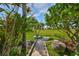Manicured backyard featuring lush greenery and a stone walkway leading to a scenic view at 8940 Park Blvd # 8940A, Seminole, FL 33777