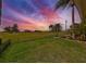 Scenic backyard view featuring a large lawn, mature trees, and a colorful sunset backdrop at 8940 Park Blvd # 8940A, Seminole, FL 33777