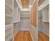 Walk-in closet with custom shelving, drawers, and hardwood floor at 8940 Park Blvd # 8940A, Seminole, FL 33777
