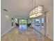 Spacious living room featuring travertine flooring, stylish lighting, and large windows at 8940 Park Blvd # 8940A, Seminole, FL 33777