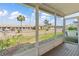 Enclosed lanai with tiled floor provides a serene view of a building, landscaping, and parking at 9808 62Nd N Ter # 9808, St Petersburg, FL 33708