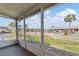 Enclosed patio overlooking well-maintained community grounds with palms and parking lot at 9808 62Nd N Ter # 9808, St Petersburg, FL 33708