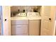 Functional laundry room features a stacked washer and dryer, neatly tucked away behind bi-fold doors for convenience and space saving at 11204 Pembridge Ct # 5, Port Richey, FL 34668