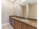 Double vanity bathroom with granite counters and dark wood cabinets at 111 N Albany Ave # 3, Tampa, FL 33606