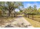 Long driveway leading to the property, framed by an ornate iron security gate at 1122 S Mulrennan Rd, Valrico, FL 33594