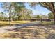 This property features a long paved driveway, wrought iron gate, green lawn, and mature trees at 1122 S Mulrennan Rd, Valrico, FL 33594