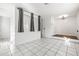 Open living room with white tiled floors, two large windows, and recessed lighting at 1122 S Mulrennan Rd, Valrico, FL 33594