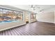 Living room with wood-look flooring, windows overlooking pool, and ceiling fans at 1122 S Mulrennan Rd, Valrico, FL 33594
