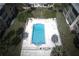 Overhead shot of a community pool featuring clear blue water, lounge chairs and palm tree landscaping at 11620 Park Blvd # 308, Seminole, FL 33772