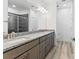 Spacious bathroom featuring double sinks, granite counters, and a tiled shower at 13065 Tinamou Ave, Weeki Wachee, FL 34614