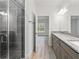 Bright bathroom with granite counters, double sinks, and a tiled shower at 13065 Tinamou Ave, Weeki Wachee, FL 34614