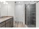 Bathroom with granite counters, wood cabinets, and a large tiled shower with glass door at 13065 Tinamou Ave, Weeki Wachee, FL 34614