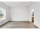 Bright bedroom features wood-look flooring, a large window, and ensuite bathroom access at 13065 Tinamou Ave, Weeki Wachee, FL 34614