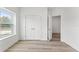 Bright bedroom with wood-look floors, closet doors and a window view to the outdoors at 13065 Tinamou Ave, Weeki Wachee, FL 34614