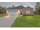 Charming single-story home with stone accents, well-maintained lawn and a two car garage at 13065 Tinamou Ave, Weeki Wachee, FL 34614