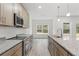 Open concept kitchen with stainless steel appliances, granite counters, and a central island at 13065 Tinamou Ave, Weeki Wachee, FL 34614