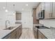 Open concept kitchen with granite countertops, stainless appliances, and wood-look flooring at 13065 Tinamou Ave, Weeki Wachee, FL 34614