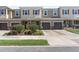 Exterior view of townhomes features neutral paint, red shutters, and individual garages at 1308 Syrah Dr, Oldsmar, FL 34677