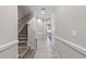 Bright hallway featuring tile floors, a staircase, and arched doorways leading to other areas of the home at 1308 Syrah Dr, Oldsmar, FL 34677