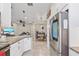 Open-concept kitchen with stainless steel refrigerator, granite counters, white cabinets, and view to living area at 1308 Syrah Dr, Oldsmar, FL 34677