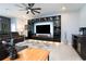 Cozy living room featuring custom built-ins, a large sectional, and a ceiling fan at 13323 Waterleaf Garden Cir, Riverview, FL 33579