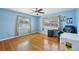 Bedroom with blue walls, hardwood floors, and two large windows at 1369 Whitacre Dr, Clearwater, FL 33764