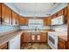 Bright kitchen with tile countertops, white appliances, and a window above the sink at 1369 Whitacre Dr, Clearwater, FL 33764