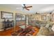 Cozy living room featuring hardwood floors, a ceiling fan, and an open view into the adjacent dining area at 1369 Whitacre Dr, Clearwater, FL 33764